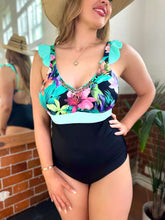 Charger l'image dans la galerie, Model showcasing the Bahia tummy control swimsuit in mint, featuring colorful floral details and hand-beaded accents.