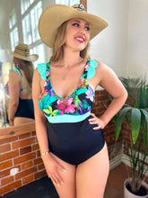 Charger l'image dans la galerie, Model wearing the Bahia tummy control swimsuit in Mint with floral ruffles and hand-beaded details, ideal for a stylish beach day.