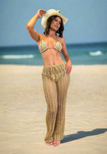 Load image into Gallery viewer, Model wearing luxury crochet trousers and bikini on the beach, showcasing a relaxed summer style.