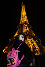 Load image into Gallery viewer, Handcrafted Fuchsia Leather Rucksack with Mola Applique showcased in front of the Eiffel Tower at night.