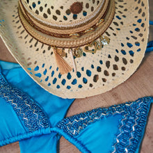 Load image into Gallery viewer, ππ₯π’π³πππππ‘ β Hand beaded Electric blue Bikini laid out with a stylish straw hat and decorative details.