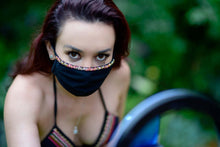 Load image into Gallery viewer, Adara hand-beaded face mask worn by a woman, blending elegance with protection in a stylish outdoor setting.