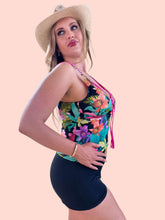 Load image into Gallery viewer, Woman in a floral tankini top and black shorts, showcasing a flattering fit and summer style with a straw hat.