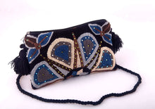 Load image into Gallery viewer, Embellished Wayuu terry cloth clutch with vibrant colors and intricate beadwork, showcasing artisanal craftsmanship.