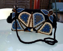 Load image into Gallery viewer, Handcrafted Wayuu terry cloth clutch with vibrant embellishments and intricate designs, perfect for adding artisanal elegance.