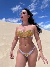 Cargar imagen en el visor de la galería, Model showcasing the Nina Hand Beaded Bikini in white with gold beads, perfect for luxury swimwear style.