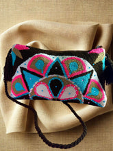 Load image into Gallery viewer, Handcrafted Wayuu terry cloth clutch with vibrant embellishments and a unique design on a textured background.