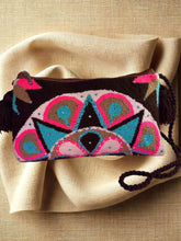 Load image into Gallery viewer, Vibrant Wayuu terry cloth clutch with unique handmade embellishments and fringe detail on a neutral fabric background.