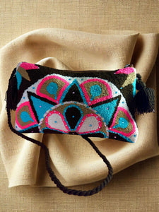 Handcrafted Wayuu terry cloth clutch featuring vibrant colors and intricate embellishments, perfect for artisanal elegance.