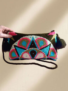 Handcrafted Wayuu terry cloth clutch with vibrant embellishments and tassels, adding artisanal elegance to any outfit.